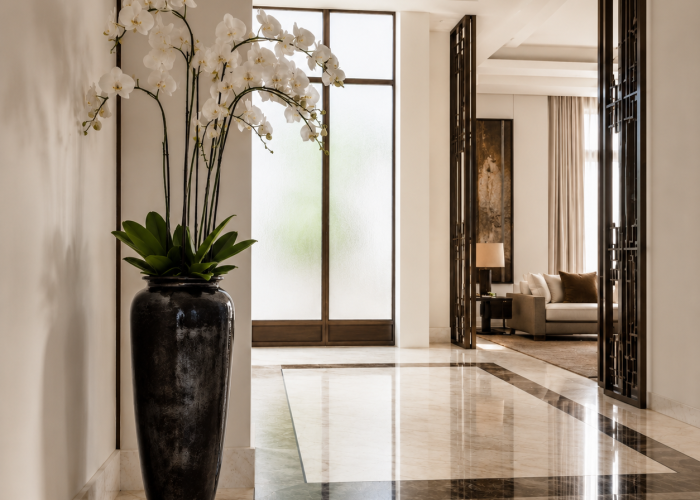 White orchid in a simple ceramic pot on a bedside table in a minimalist Dubai bedroom