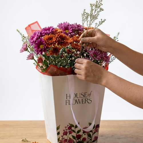 Hands arranging fresh flowers in a vase at home in Dubai